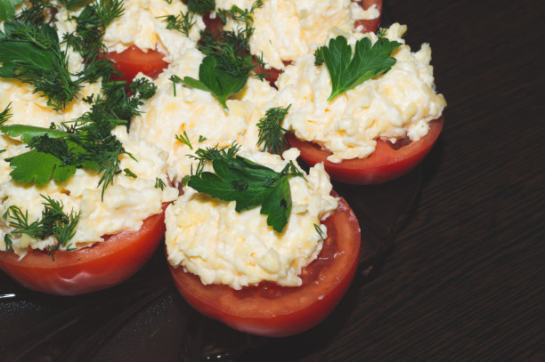 番茄配芝士和欧芹。从蔬菜开胃菜。两半西红柿和芝士奶油图片下载