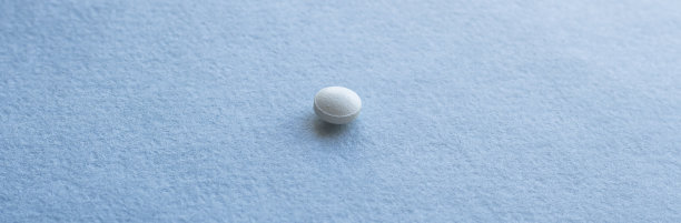 白色药片和包装上的蓝色背景图片下载