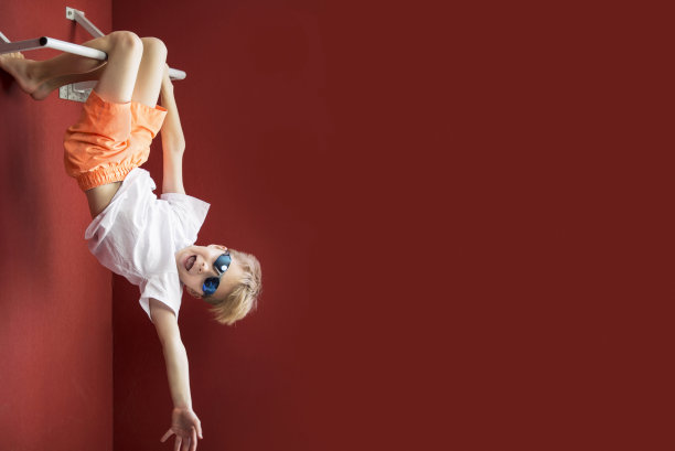 滑稽快乐的小男孩挂在单杠上图片下载