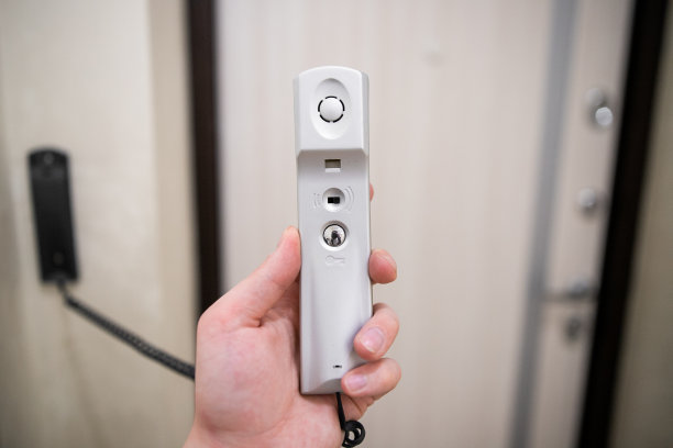 公寓墙上的对讲机，一个男人手里拿着听筒图片下载
