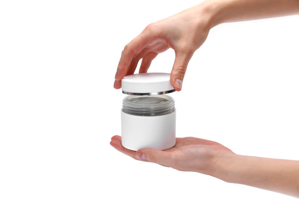 女人的手，女孩拿着一个打开的奶油罐，特写，白色背景，拷贝空间，文字，俯视图。图片下载