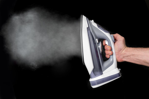 蒸汽熨斗上的黑色背景图片下载