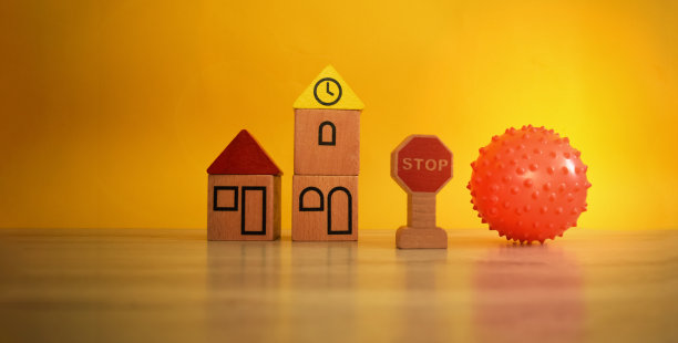 玩具木屋和一个红球。一张在甲型h1n1流感大流行期间用玩具来引起人们对自我隔离话题的关注的图片。图片下载