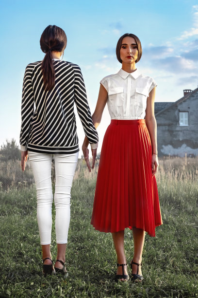 户外时尚肖像两个年轻漂亮的女人穿着时尚的衣服在街上摆姿势图片下载