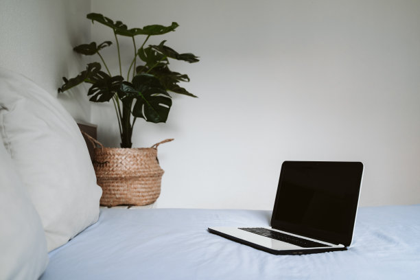 舒适的工作场所，远程工作。在床上打开笔记本电脑。图片下载