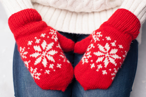 戴着红色手套的手躺在女人的膝盖上图片下载