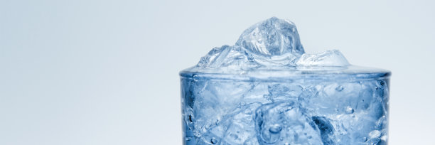 一个玻璃杯的特写，里面装满了冰和水。图片下载