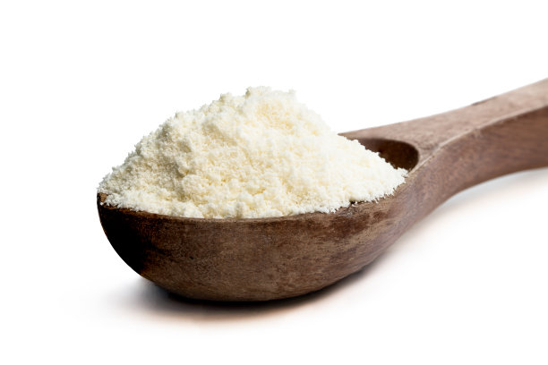 全脂奶粉在木勺上隔离白色图片下载