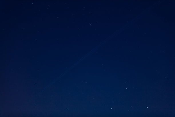 最近在黑暗的夜空中可以看到卫星轨迹——互联网卫星经过并留下轨道。图片下载