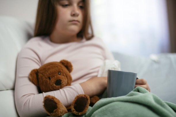 漂亮的小女孩在家喝茶库存照片。图片下载