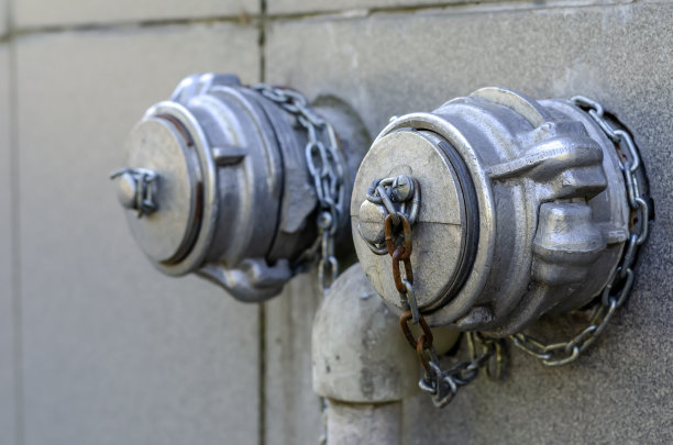 铝制消火栓安装在墙上，盖上链条。图片下载