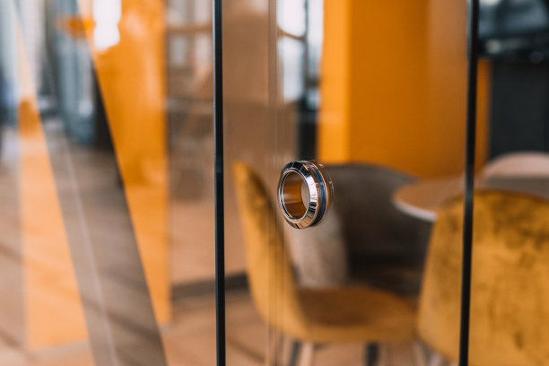 现代办公室玻璃门上的圆形金属门把手图片下载