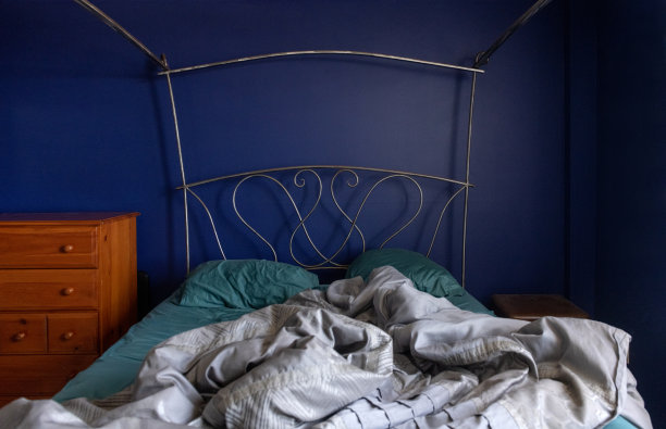 冠状病毒居家期间，蓝色卧室室内凌乱凌乱的床图片下载