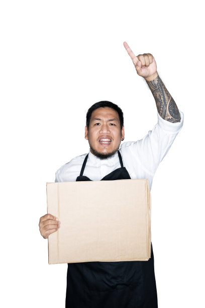留着胡子的亚洲男侍者、穿着黑色围裙的厨师正拿着纸板，在白色的背景下伸出手指。抗议、注意、要求的概念。放置文本或复制空间。剪切路径。图片下载