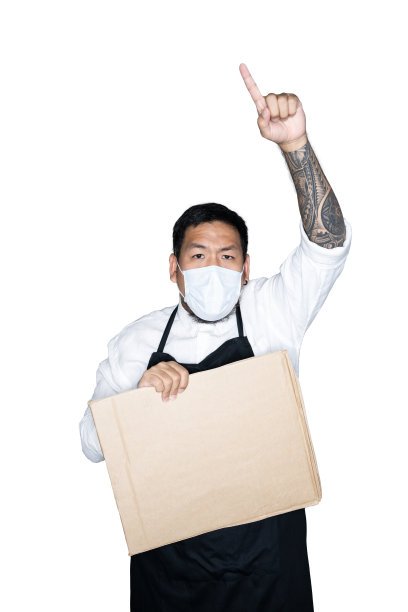 留着胡子的亚洲男侍者、厨师穿着黑色围裙，戴着医用口罩，拿着纸板，在白色背景下伸出手指。抗议、注意、要求的概念。放置文本或复制空间。剪切路径。图片下载