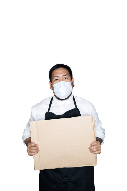 留着胡子的亚洲男侍者、身穿黑色围裙带着医用口罩的厨师正拿着纸板在白色背景下工作。抗议、注意、要求的概念。放置文本或复制空间。剪切路径。图片下载