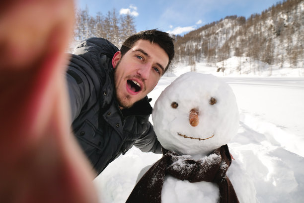 在冬天的一天，一个男人在山里打视频电话，用电话问候他的妻子或朋友。图片下载