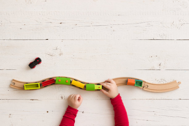 从上面俯瞰铁路上的木制玩具火车。孩子的手玩教育玩具。图片下载