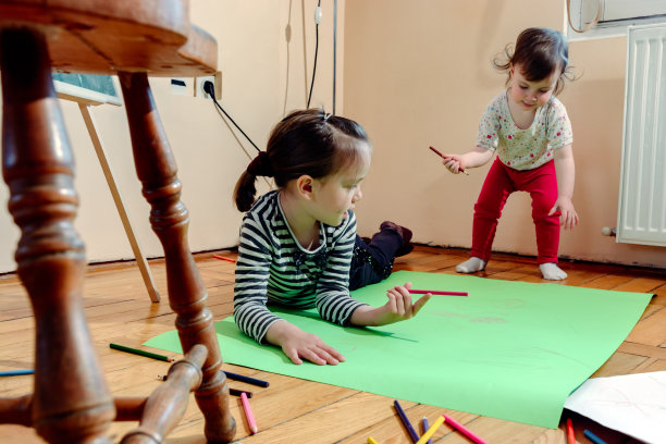 两个小女孩在家里用蜡笔画画图片下载