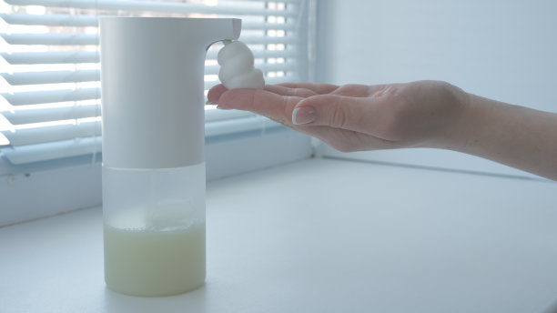 女孩用自动泡沫肥皂机，洗手，关上，关上，放在窗台上，右手图片下载