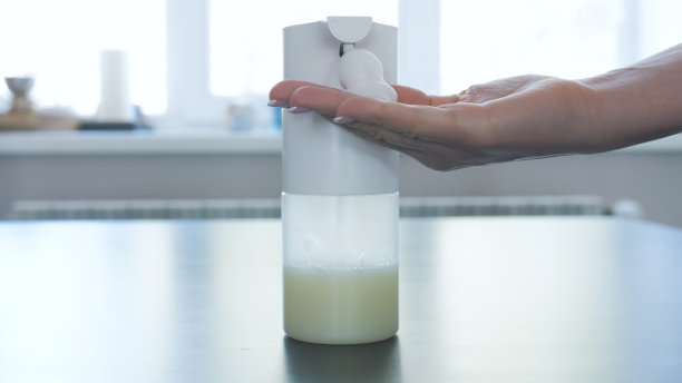 女孩和男人用自动泡沫肥皂机洗手，关上，关上，放在窗台上图片下载