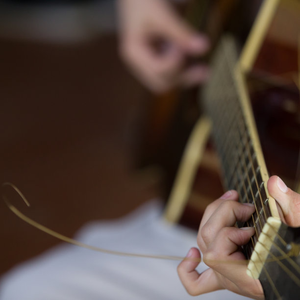 在音乐会上弹奏吉他的音乐家的手的特写。图片下载