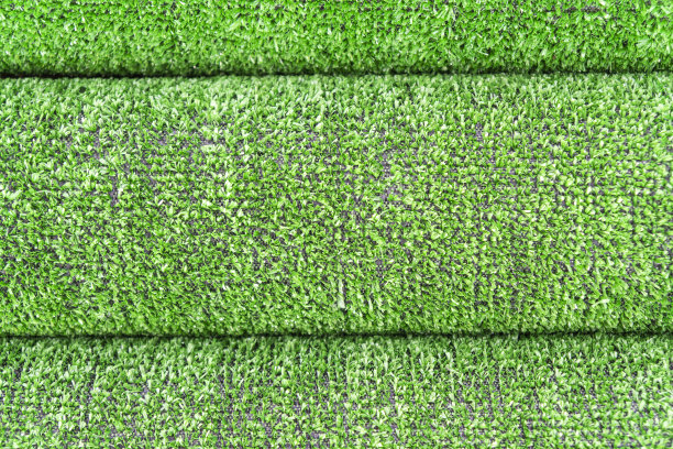 人造草草坪纹理。人造草皮的背景。用人造草绿化。滚动人造草皮铺设背景纹理。一卷合成草层图片下载