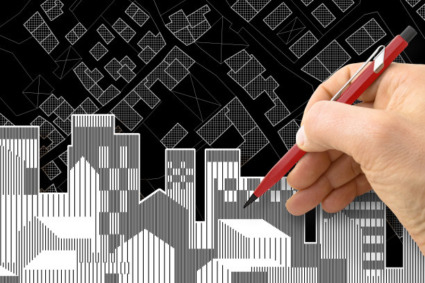 建筑师或工程师在一个虚构的城市地图上画一个住宅建筑，地图上有建筑物、田野和道路图片下载