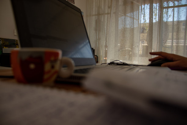 冠状病毒迫使许多人在家工作，在临时搭建的桌子上喝着pc杯咖啡。图片下载