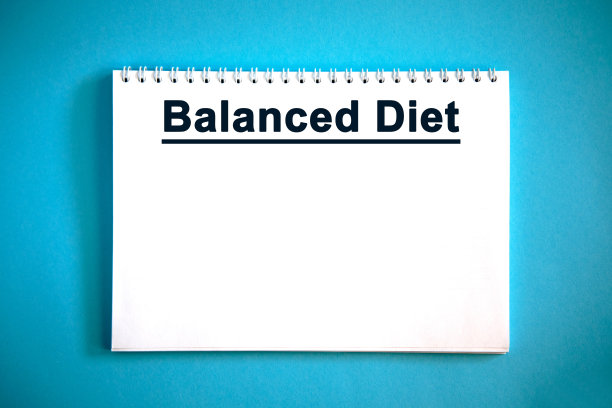 平衡饮食-文字在白色笔记本在蓝色的背景图片下载