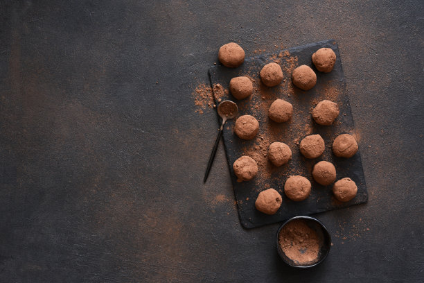 黑色背景下的石头板上的松露巧克力。从以上观点。图片下载