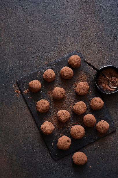 黑色背景下的石头板上的松露巧克力。从以上观点。图片下载