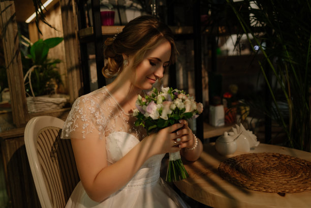 雪地新娘手捧鲜花，闭目轻嗅。婚礼前的照片拍摄。图片下载