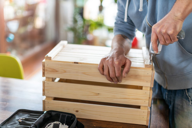 工人在家里用电动工具钻木箱图片下载