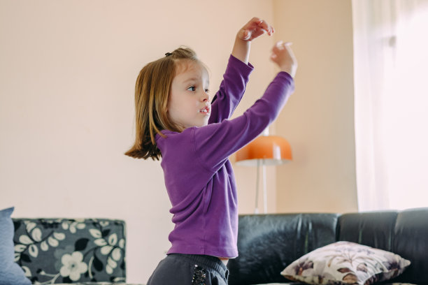 可爱的小女孩在家里看电视学跳舞图片下载