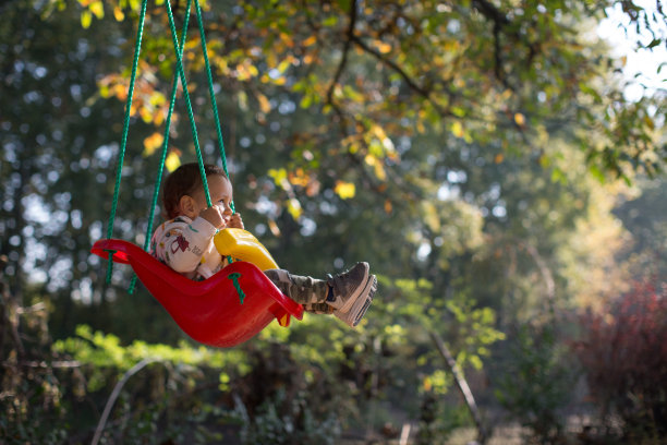 一个微笑的小男孩在大自然中摇摆图片下载