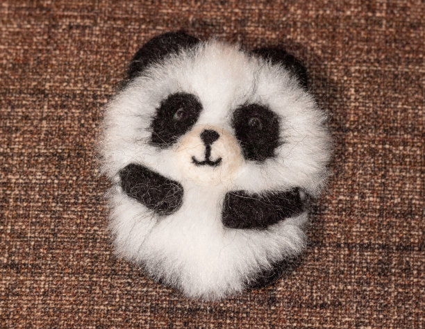 有趣的熊猫胸针。由天然羊毛和人造毛皮制成的手工制品。图片下载