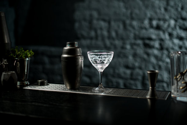 玻璃装饰和金属摇壶站在黑暗的酒吧。图片下载