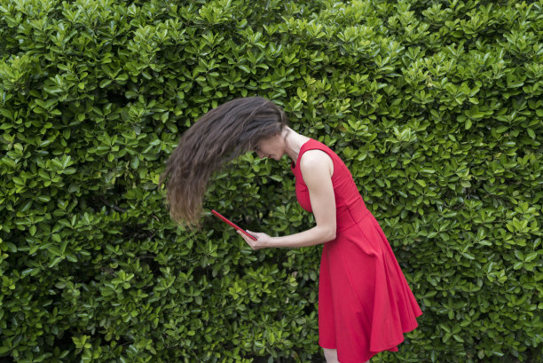 红衣女士吮着她的平板电脑图片下载
