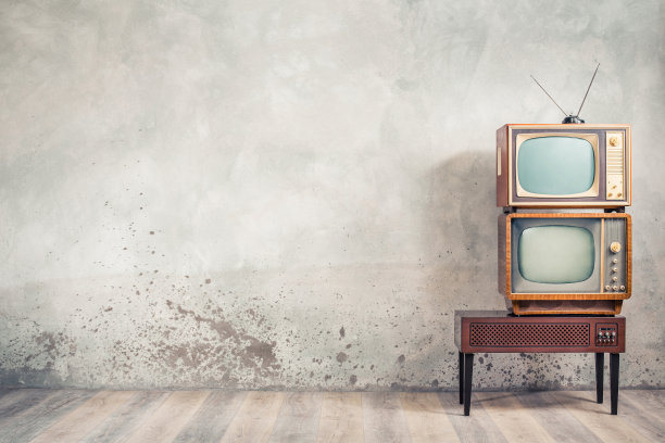 复古经典的老式模拟电视接收机和老化的木制电视架与过时的放大器前老化的混凝土墙背景。广播,新闻的概念。复古风格滤镜照片图片下载