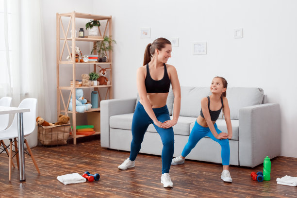 水平工作室概念在家白光背景与运动设备。教练女女女孩瑜伽教练训练小美小女孩在室内做伸展运动。图片下载