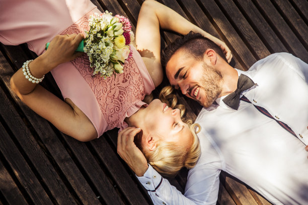 微笑的新娘和新郎躺在一起放松图片下载