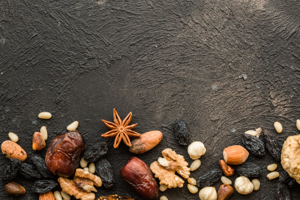 干果和坚果混合在黑色表面上，俯视图。头顶上，平躺着，从上面看。副本的空间。图片下载