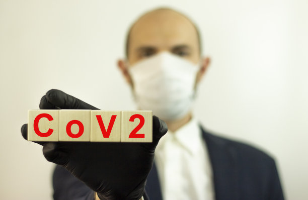 阻止感染健康人在木质Cov2立方体上刻了字照片中的男子戴着防护口罩和手套以预防传染病和流感。医疗保健的概念。图片下载