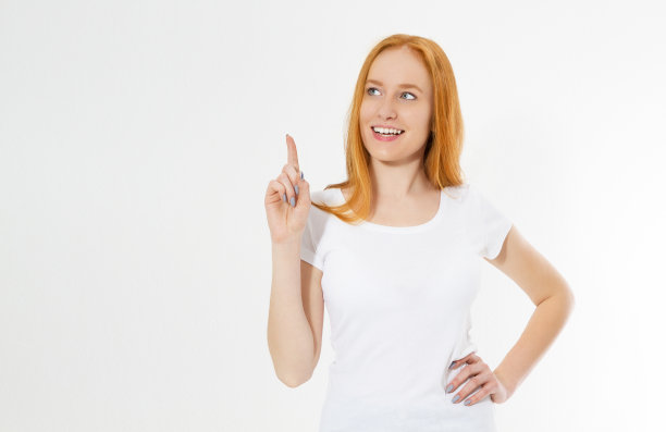 照片微笑的红发女士孤立在白色的背景指向她的手指在eureka标志，有伟大的创新的想法，理解或解决方案，她刚刚得到。副本的空间。图片下载
