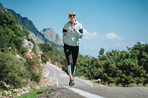 戴着太阳镜的女人在公路上跑，高山，高地图片下载