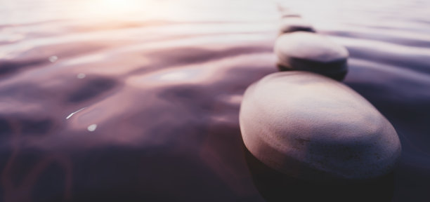 日落时平静水面上的禅石。水疗健康和和谐。图片下载