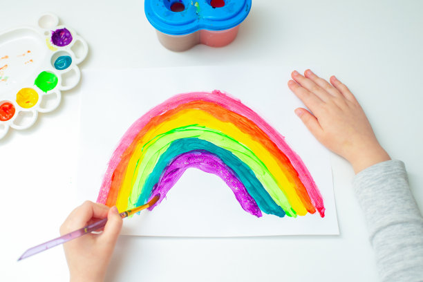 孩子在画彩虹。素材图片