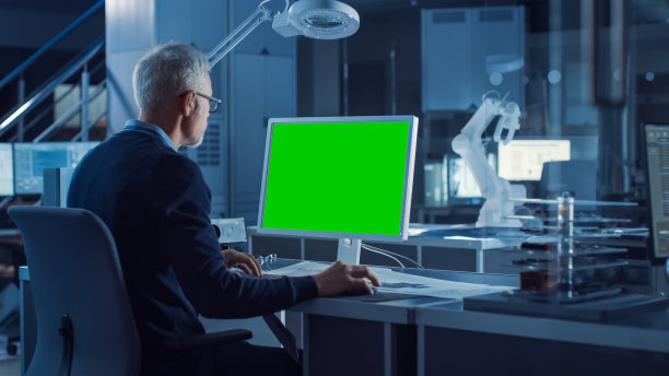 专业的重工业工程师在绿色模拟屏幕计算机上工作。工程局和工业设计机构与各种机器人，建筑和机械部件图片下载