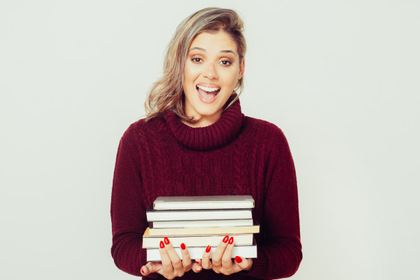 兴奋的年轻女子拿着书图片下载